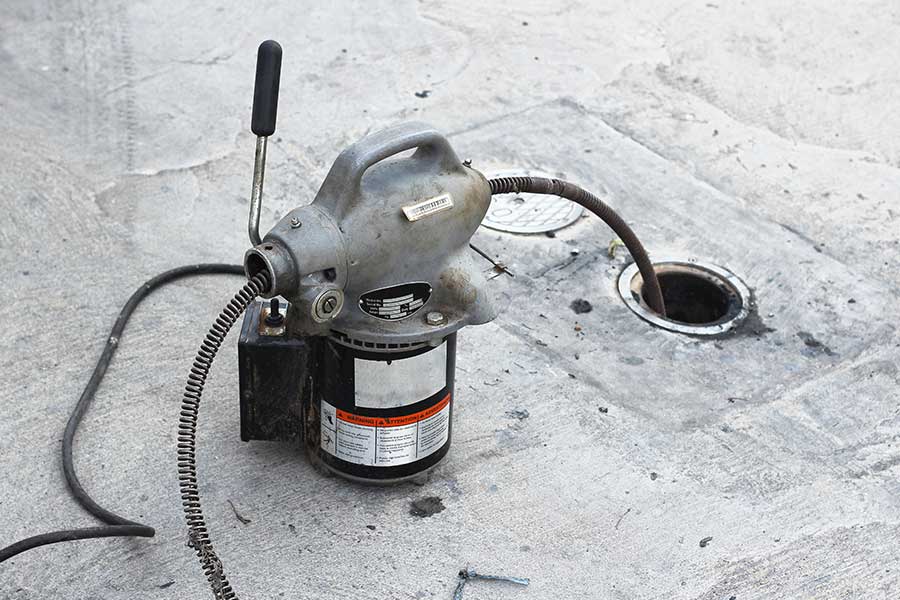 Electric drain auger clearing a clogged pipe during rooter service in Lake Oswego