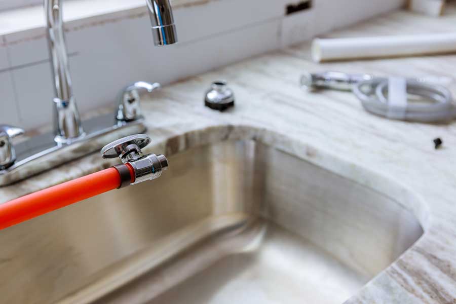 Faucet and water line setup during sink installation in Lake Oswego
