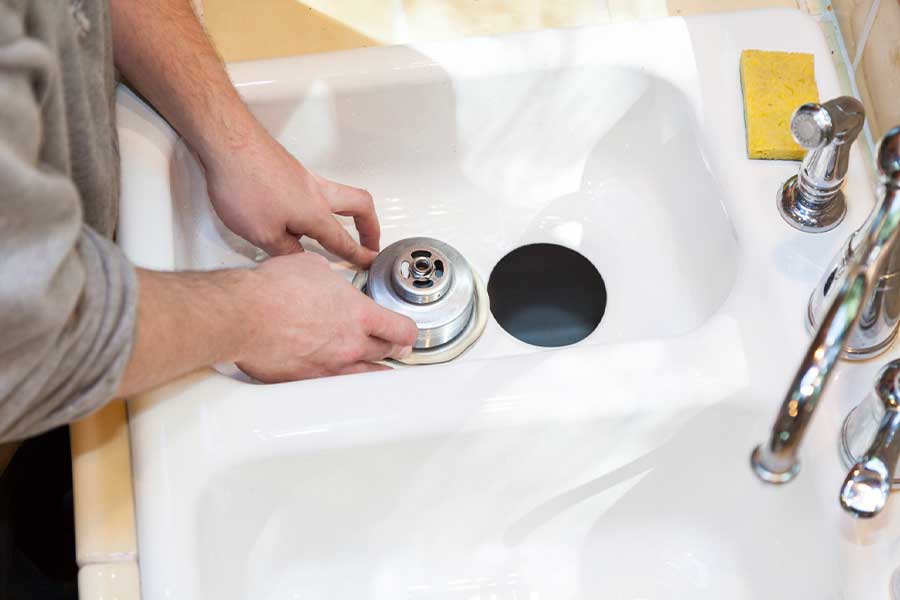 Installing sink drain assembly during bathroom sink setup in Lake Oswego